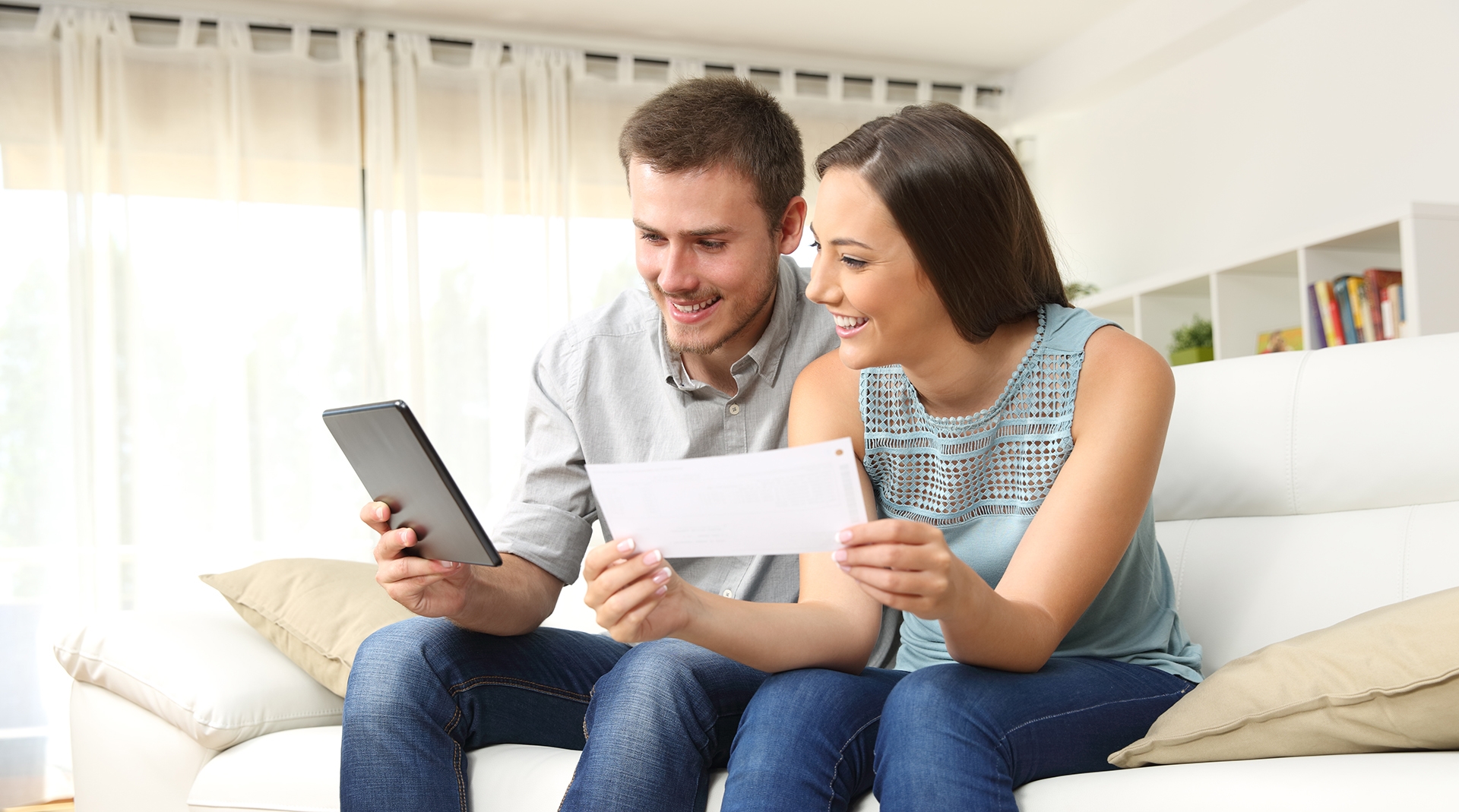 two people looking at a tablet on the couch